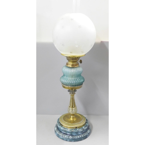 809 - A brass oil lamp with blue glass reservoir and pottery base, replacement shade