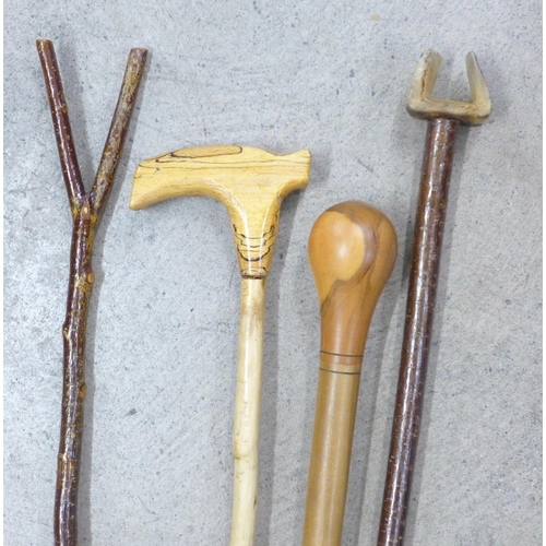 827 - Four walking canes, carved wood, one with horn handle