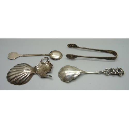 850 - A silver tea caddy spoon, a pair of silver sugar bows, a silver backed brush and two spoons