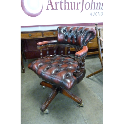 10 - A mahogany and oxblood red leather revolving Captain's desk chair