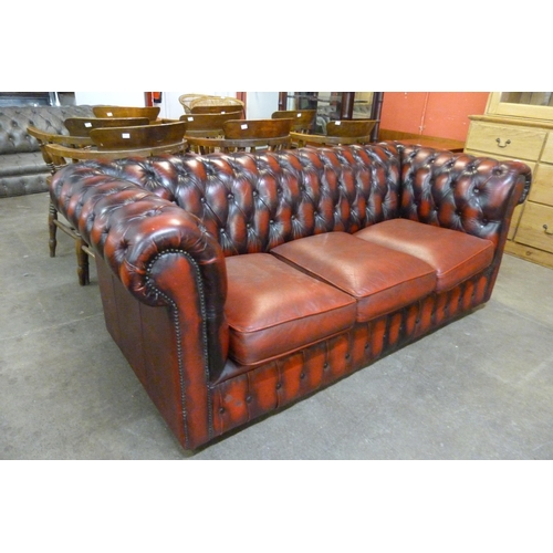 17 - An oxblood red leather Chesterfield settee