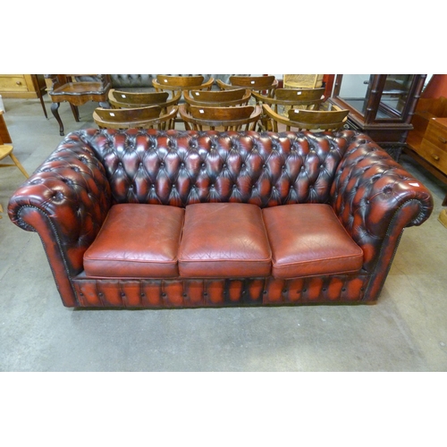 17 - An oxblood red leather Chesterfield settee