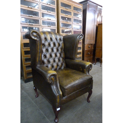 21 - An olive green Chesterfield wingback armchair