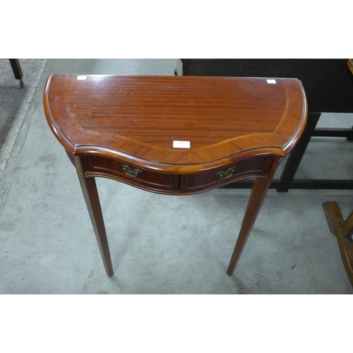 229 - A mahogany serpentine two drawer hall table