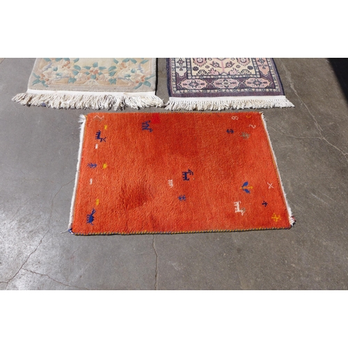 261 - An eastern hand knotted rug, a Chinese rug and a mat