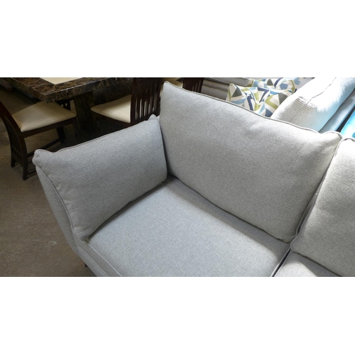 1529 - A stone upholstered three seater sofa on semi exposed hardwood frame