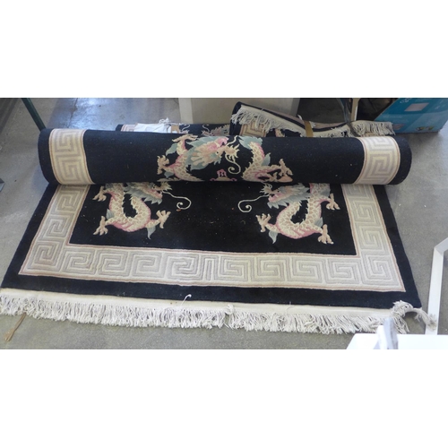 1598 - A set of  three matching black and cream rugs