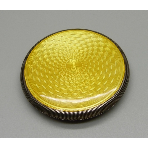 1027 - A white metal and yellow guilloche enamel compact, small area of wear to the enamel near hinge