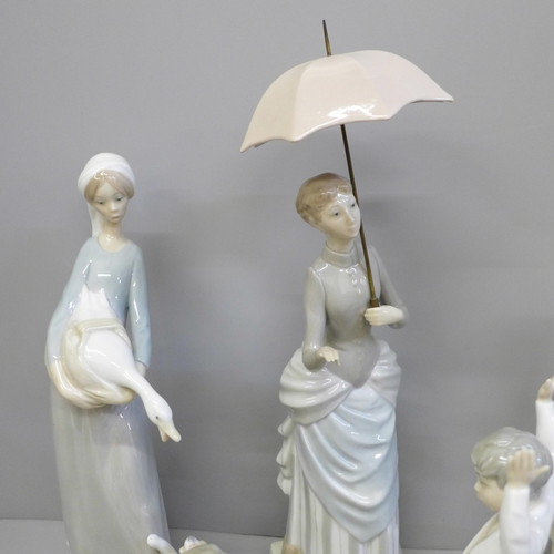 610 - Four Lladro figures including dog and children on see-saw, one other similar of a lady with umbrella