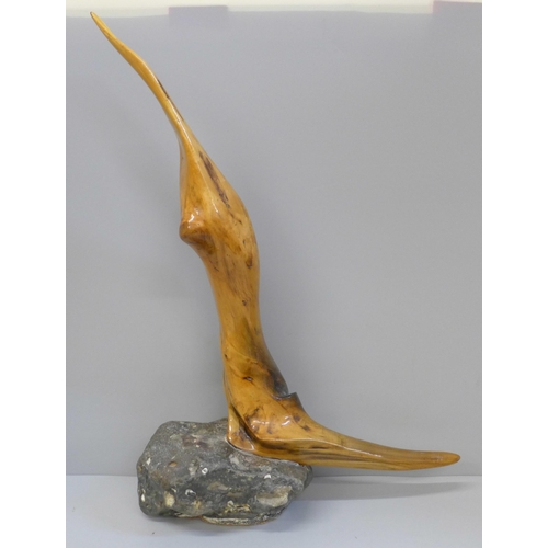 616 - A lacquered driftwood sculpture on a stone base