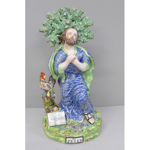 647 - A lead-glazed Staffordshire pearlware figure, titled St. Peter, with bocage, Peter kneels with hands... 