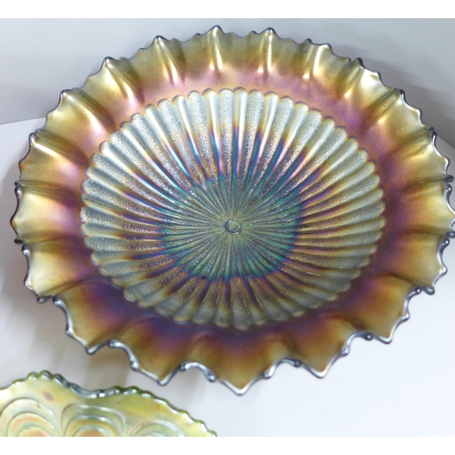 864A - Five items of carnival glass including a Northwood ruffled stippled ray bowl and an amber peacock an... 