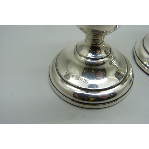 892 - A silver topped Walker & Hall claret jug, and a pair of silver candlesticks