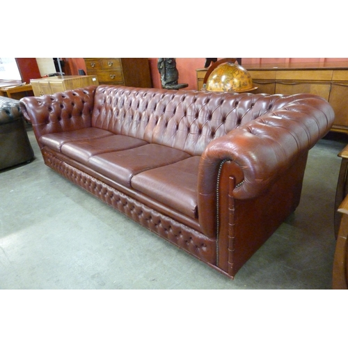 104 - An oxblood red leather Chesterfield settee