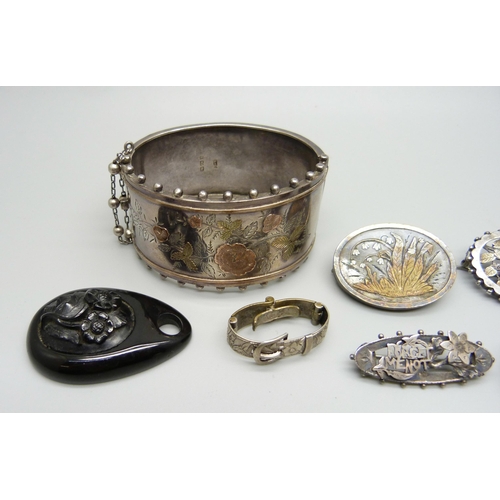 990 - A Victorian silver bangle, four silver and white metal brooches, one lacking pin, a jet pendant, etc... 