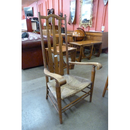 215 - An Arts and Crafts oak and rush seated fireside chair