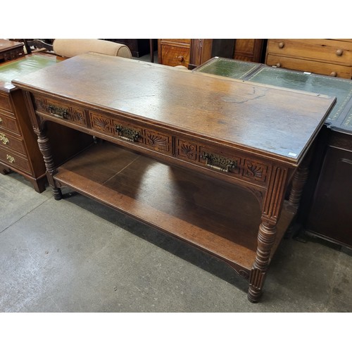 127 - A Victorian Aesthetic Movement carved oak three drawer serving table