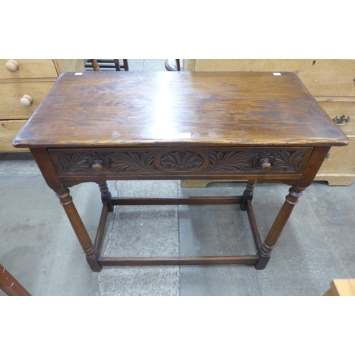 111 - A 17th Century style carved oak single drawer side table