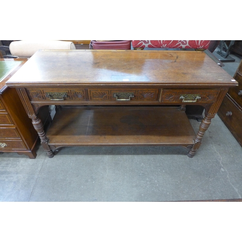 127 - A Victorian Aesthetic Movement carved oak three drawer serving table