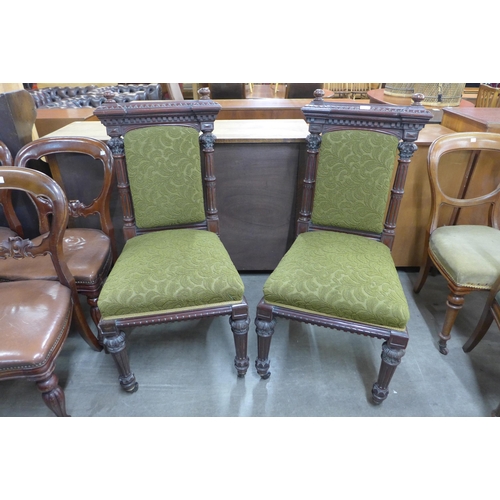 129 - A pair of Victorian carved mahogany and green fabric upholstered hall chairs