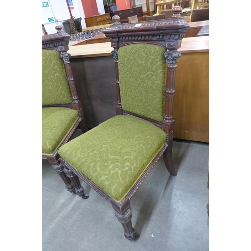 129 - A pair of Victorian carved mahogany and green fabric upholstered hall chairs