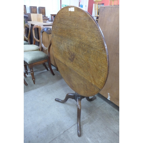 133 - A George III oak circular tilt top tripod table