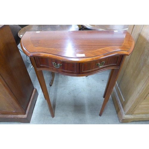 164 - A mahogany serpentine two drawer hall table