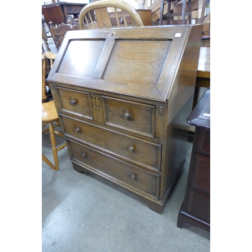 174 - An carved oak linenfold bureau