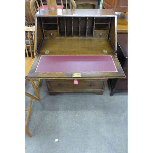 174 - An carved oak linenfold bureau