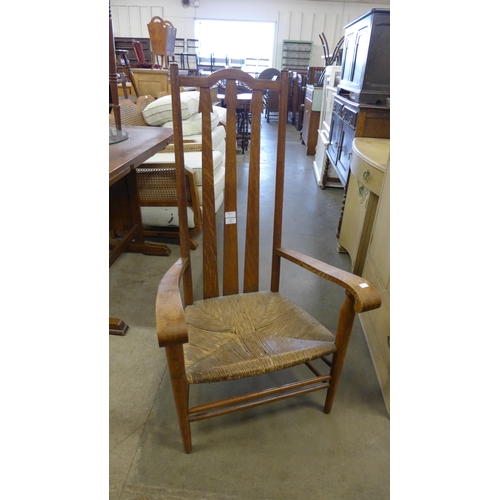 215 - An Arts and Crafts oak and rush seated fireside chair