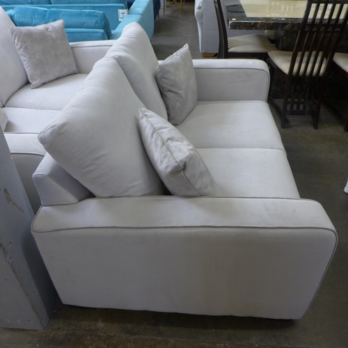 1328 - A frost white with grey piping corduroy upholstered two seater sofa