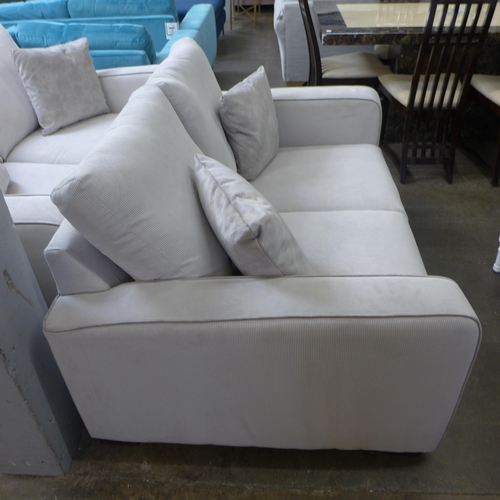 1329 - A frost white with grey piping corduroy upholstered two seater sofa