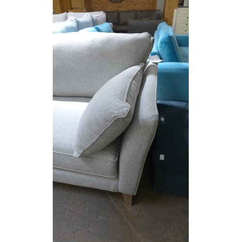 1406 - A stone upholstered three seater sofa on semi exposed hardwood frame