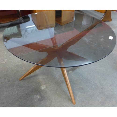 25 - A Danish Sika Mobler teak and glass topped circular spider leg coffee table, designed by Vladimir Ka... 
