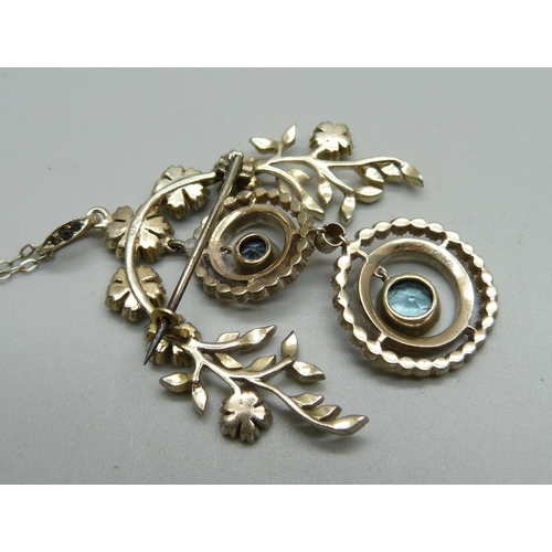 1030 - A silver pendant/brooch set with paste stones on a silver chain, marked 925, 43mm wide