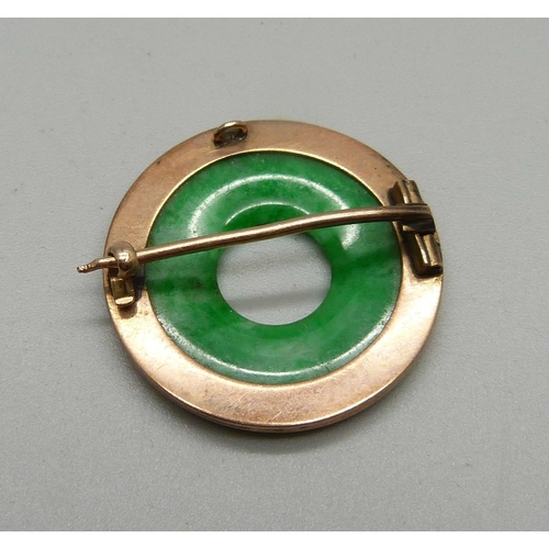 1031 - A yellow metal set jade brooch, 26mm