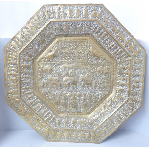612 - An Indian embossed octagonal brass plaque, 59cm