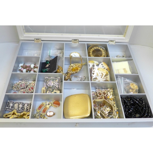 688 - A display case with costume jewellery, compacts and a pocket watch