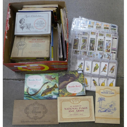 696 - Cigarette cards; a box of cigarette and trade cards in albums and sleeves