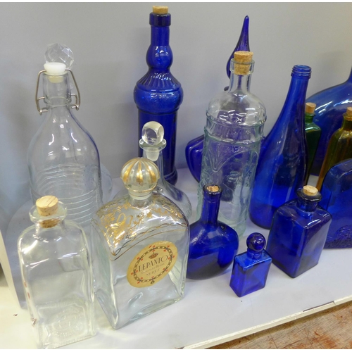 716 - A collection of glass bottles including Bristol blue and green glass