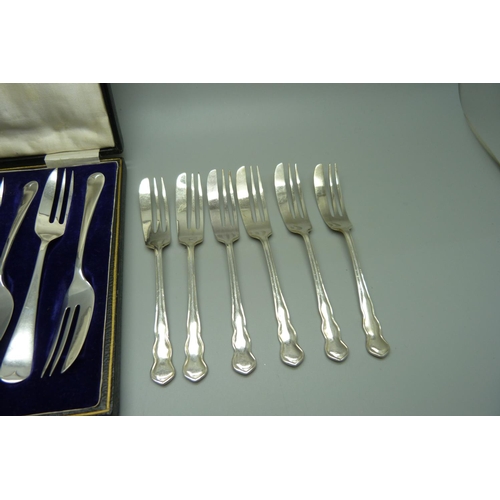 822 - A set of six silver cake forks, Sheffield 1923, 93g, and a set of six electro plated forks