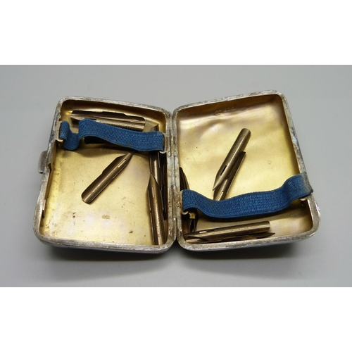 832 - A Victorian silver cigarette case with inscription, 84g, and a collection of pen nibs