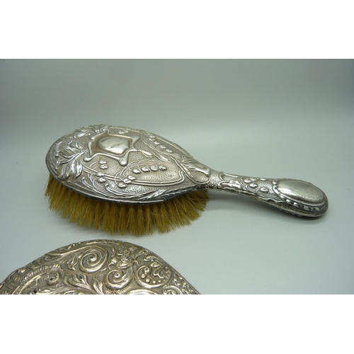 858 - A silver hand mirror back and brush, a/f