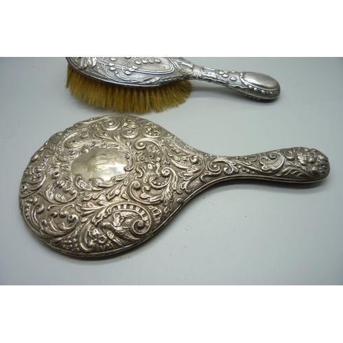 858 - A silver hand mirror back and brush, a/f