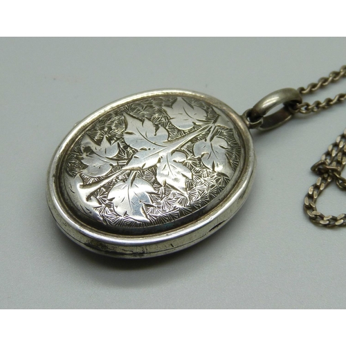 888 - A white metal locket on a silver chain