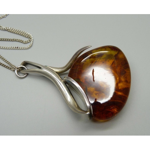 915 - A large silver and amber set pendant on a silver chain