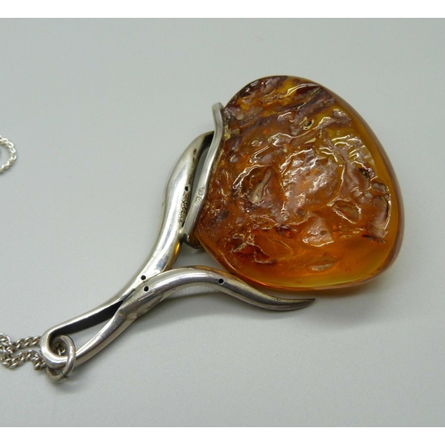 915 - A large silver and amber set pendant on a silver chain