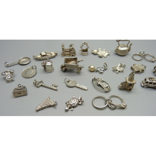 969 - Twenty-five silver and white metal charms, all stamped or test as silver, 68g