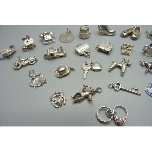 979 - Twenty-five silver and white metal charms, all stamped or test as silver, 72g