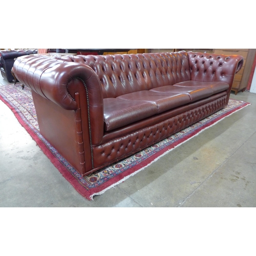 107 - An oxblood red leather Chesterfield settee